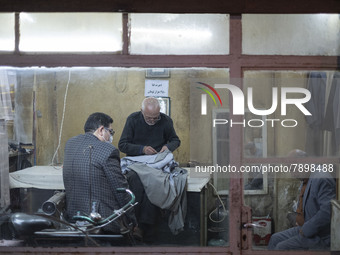 Iranian men sit at an old sewing shop in the holy city of Qom 145Km (90 miles) south of Tehran at night on March 10, 2022. (