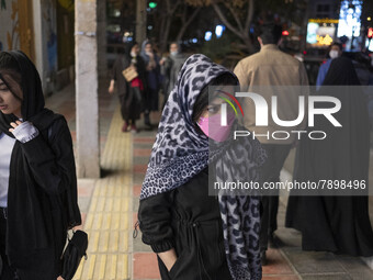 Two Iranian young women walk along an avenue in the holy city of Qom 145Km (90 miles) south of Tehran on March 10, 2022. (