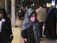 Two Iranian young women walk along an avenue in the holy city of Qom 145Km (90 miles) south of Tehran on March 10, 2022. (