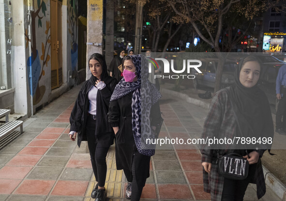 Iranian young women walk along an avenue in the holy city of Qom 145Km (90 miles) south of Tehran on March 10, 2022. 