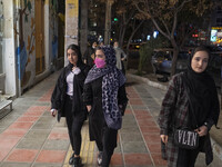 Iranian young women walk along an avenue in the holy city of Qom 145Km (90 miles) south of Tehran on March 10, 2022. (