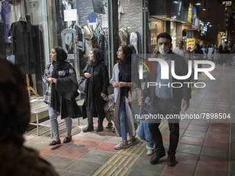 Iranian women look at a shop window while walking along a street-side in the holy city of Qom145Km (90 miles) south of Tehran on March 10, 2...