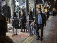 Iranian women look at a shop window while walking along a street-side in the holy city of Qom145Km (90 miles) south of Tehran on March 10, 2...