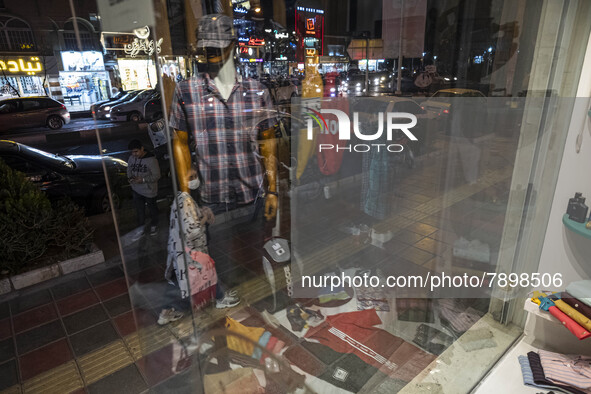 An Iranian young woman looks at a shop window in the holy city of Qom145Km (90 miles) south of Tehran on March 10, 2022. 