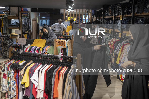 An Iranian veiled woman looks at a pant while shopping at a dress shop in the holy city of Qom145Km (90 miles) south of Tehran on March 10,...