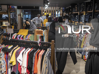 An Iranian veiled woman looks at a pant while shopping at a dress shop in the holy city of Qom145Km (90 miles) south of Tehran on March 10,...