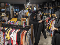 An Iranian veiled woman looks at a pant while shopping at a dress shop in the holy city of Qom145Km (90 miles) south of Tehran on March 10,...