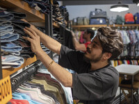 An Iranian salesman adjusts jeans at a shelf in a dress shop in the holy city of Qom145Km (90 miles) south of Tehran on March 10, 2022. (