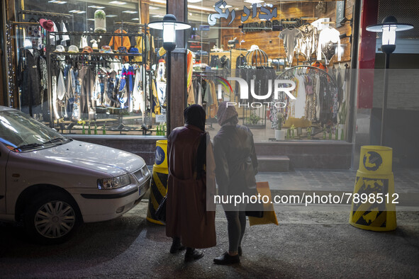 An Iranian woman (L) and her daughter look at a dress shop window while standing on a street-side in the holy city of Qom145Km (90 miles) so...