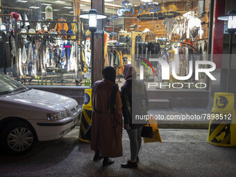 An Iranian woman (L) and her daughter look at a dress shop window while standing on a street-side in the holy city of Qom145Km (90 miles) so...