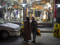 An Iranian woman (L) and her daughter look at a dress shop window while standing on a street-side in the holy city of Qom145Km (90 miles) so...