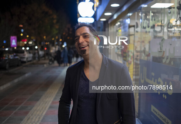 An Iranian man smiles as he poses for a photograph on a street-side in the holy city of Qom 145Km (90 miles) south of Tehran on March 10, 20...