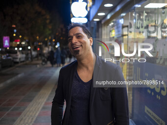 An Iranian man smiles as he poses for a photograph on a street-side in the holy city of Qom 145Km (90 miles) south of Tehran on March 10, 20...