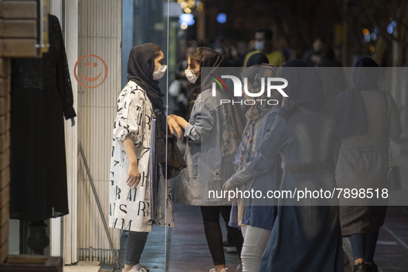 Iranian youths speak with each other while standing in front of a dress shop window in the holy city of Qom 145Km (90 miles) south of Tehran...