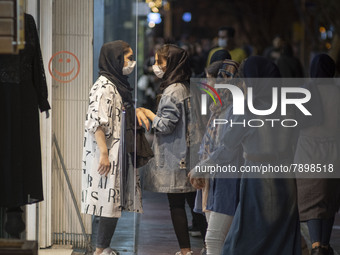 Iranian youths speak with each other while standing in front of a dress shop window in the holy city of Qom 145Km (90 miles) south of Tehran...