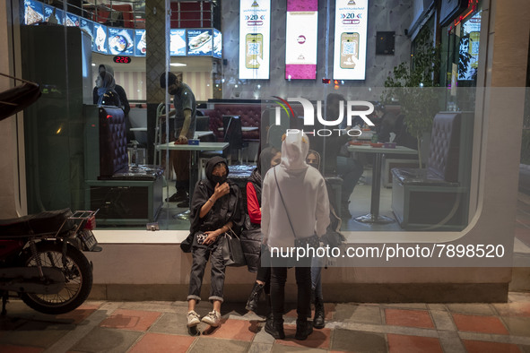 Iranian youths out of a fast-food restaurant in the holy city of Qom 145Km (90 miles) south of Tehran on March 10, 2022. 