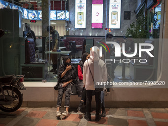 Iranian youths out of a fast-food restaurant in the holy city of Qom 145Km (90 miles) south of Tehran on March 10, 2022. (