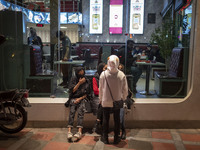 Iranian youths out of a fast-food restaurant in the holy city of Qom 145Km (90 miles) south of Tehran on March 10, 2022. (