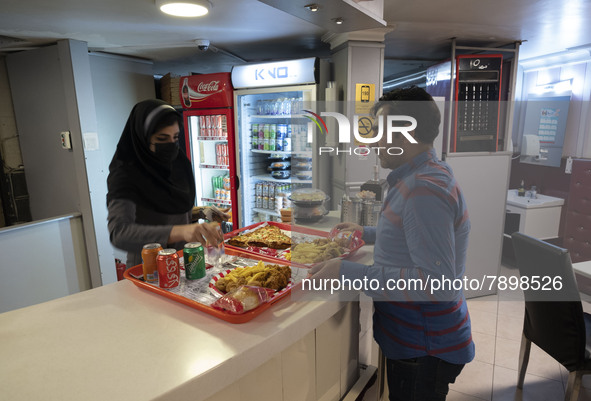 An Iranian man receives fast-foods ordered in a fast-food restaurant in the holy city of Qom 145Km (90 miles) south of Tehran on March 10, 2...