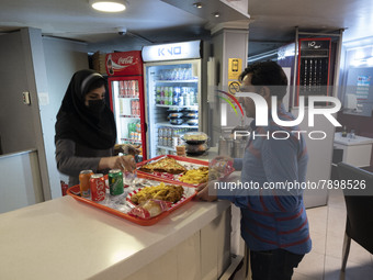 An Iranian man receives fast-foods ordered in a fast-food restaurant in the holy city of Qom 145Km (90 miles) south of Tehran on March 10, 2...