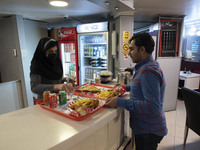 An Iranian man receives fast-foods ordered in a fast-food restaurant in the holy city of Qom 145Km (90 miles) south of Tehran on March 10, 2...