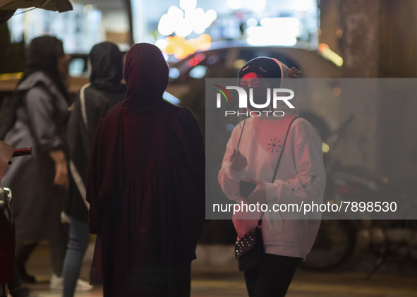 An Iranian young girl wearing a protective face mask looks on while standing out of a fast-food restaurant in the holy city of Qom 145Km (90...