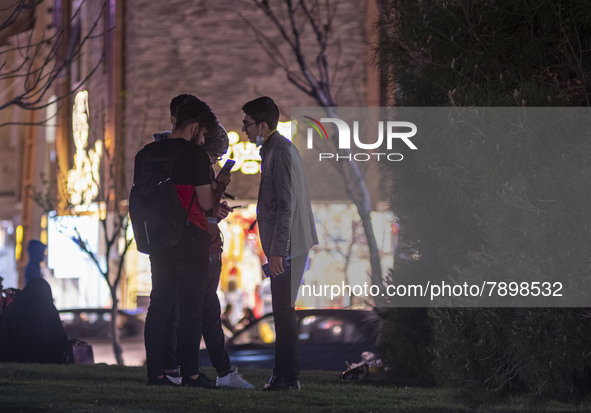 Iranian youths stand together as they check their pages on Social Media platforms on their smartphones at a square in the holy city of Qom 1...