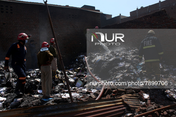 Firemen spray water across damaged homes after a fire broke out in a makeshift settlement area around Gokulpuri in New Delhi, India on March...