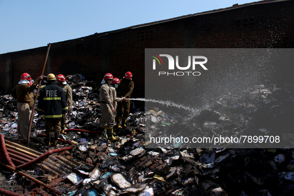 Firemen spray water across damaged homes after a fire broke out in a makeshift settlement area around Gokulpuri in New Delhi, India on March...