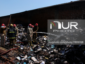 Firemen spray water across damaged homes after a fire broke out in a makeshift settlement area around Gokulpuri in New Delhi, India on March...