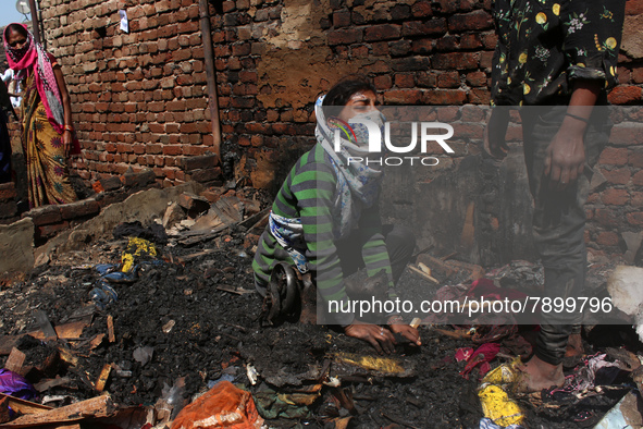 A girl cries as she salvages belongings among the charred remains of her home after a fire broke out in a makeshift settlement area around G...