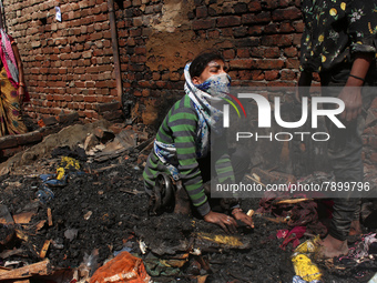 A girl cries as she salvages belongings among the charred remains of her home after a fire broke out in a makeshift settlement area around G...