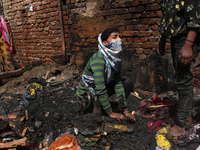 A girl cries as she salvages belongings among the charred remains of her home after a fire broke out in a makeshift settlement area around G...