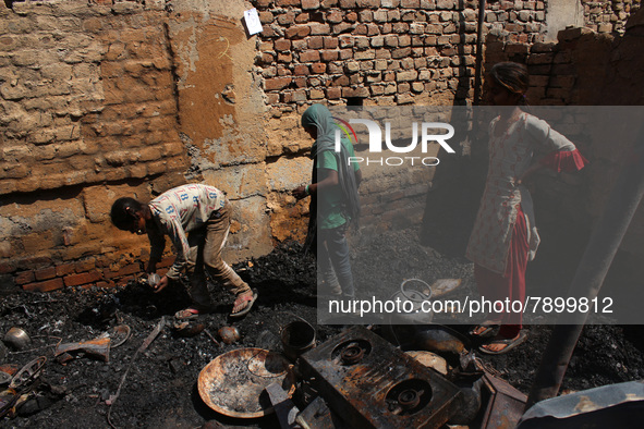 Girls salvage belongings among the charred remains of their home after a fire broke out in a makeshift settlement area around Gokulpuri in N...