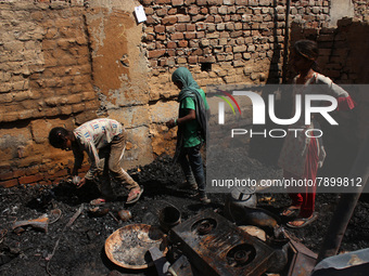 Girls salvage belongings among the charred remains of their home after a fire broke out in a makeshift settlement area around Gokulpuri in N...