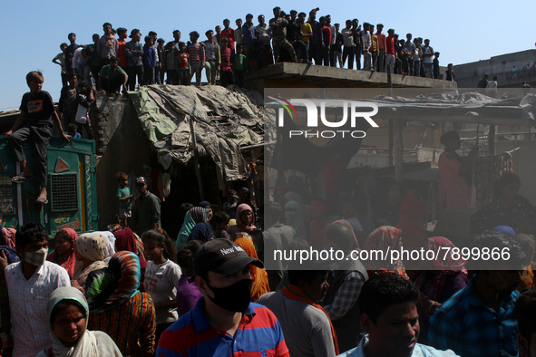 People gather to listen as Delhi's Chief Minister Arvind Kejriwal addresses during his visit to the site after a fire broke out in a makeshi...