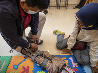 COKI TOBING put on porthetic limb to RAFFASYA son, as his mother Mrs. ENI watched. COKI TOBING, the owner of a prosthetic limb and assistive...