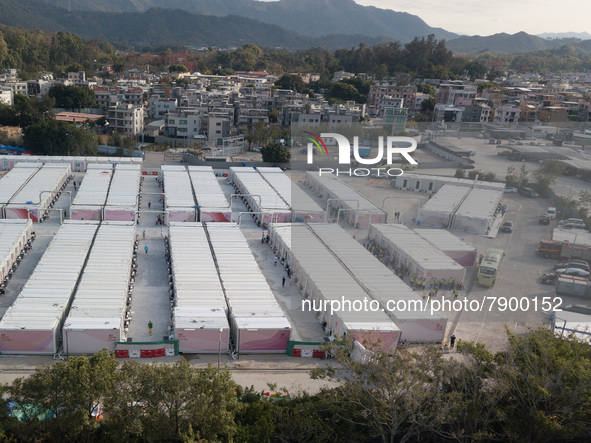  A view by drone of the San Tin Community Isolation Facility. On the right, new arrivals are surrounded by staff after getting down from the...