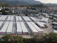  A view by drone of the San Tin Community Isolation Facility. On the right, new arrivals are surrounded by staff after getting down from the...