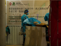 Nurses in PPE assist patients in a makeshift triage area at Princess Margaret Hospital, in Hong Kong, China, on March 16, 2022, in Hong Kong...