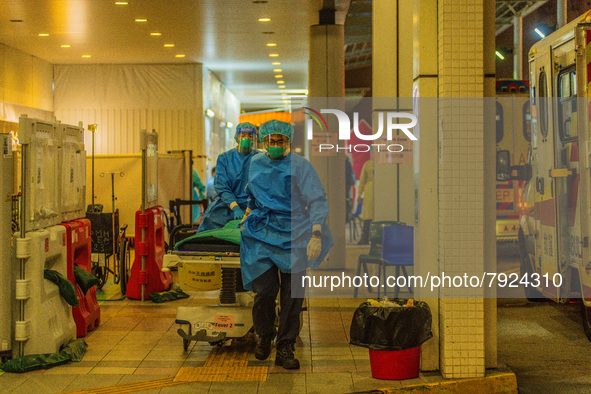 Paramedics bring a hospital bed to transfer an elderly patient to the Accident & Emergency ward of Princess Margaret hospital, in Hong Kong,...