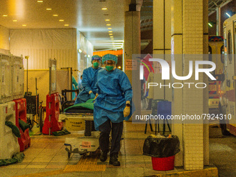 Paramedics bring a hospital bed to transfer an elderly patient to the Accident & Emergency ward of Princess Margaret hospital, in Hong Kong,...