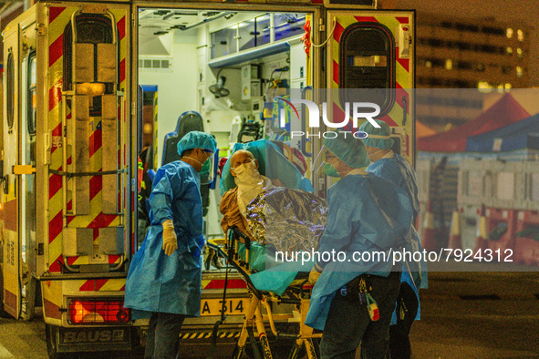 An elderly patient is transferred out of an ambulance by paramedics at Princess Margaret hospital, in Hong Kong, China, on March 16, 2022, i...