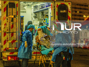 An elderly patient is transferred out of an ambulance by paramedics at Princess Margaret hospital, in Hong Kong, China, on March 16, 2022, i...