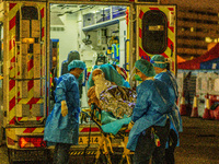 An elderly patient is transferred out of an ambulance by paramedics at Princess Margaret hospital, in Hong Kong, China, on March 16, 2022, i...