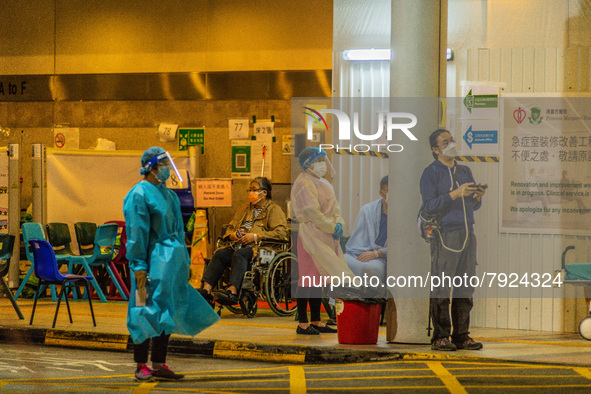 Nurses and paramedics stand guard near a makeshift triage area at Princess Margaret hospital, while patients wait there too, in Hong Kong, C...