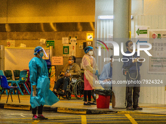 Nurses and paramedics stand guard near a makeshift triage area at Princess Margaret hospital, while patients wait there too, in Hong Kong, C...