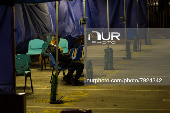 A lonely patient is seated in a triage area for COVID patients at Caritas Medical Centre, in Hong Kong, China, on March 16, 2022, in Hong Ko...