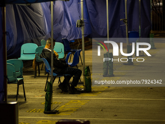 A lonely patient is seated in a triage area for COVID patients at Caritas Medical Centre, in Hong Kong, China, on March 16, 2022, in Hong Ko...