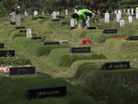 Officers clean the COVID-19 graveyard in Srengsesngsawah, South Jakata, Jakarta, Indonesia. Towards Ramadan, officers clean the graves, so t...